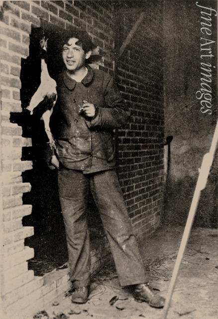 Unbekannter Fotograf - Chaim Soutine (1893-1943) mit Huhn vor Backsteinmauer